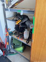 Full view of gray metal utility shelf with particleboard tiers