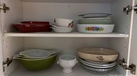 Cabinet shelves showing Pyrex bowls, Lagostina bakeware, assorted plates and bowls