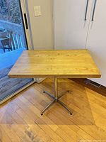 overall view of table with butcher block top and chrome pedestal base