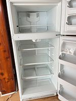 Open view of Frigidaire refrigerator interior showing freezer, shelves, door bins, crisper drawers