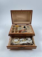 open jewelry box showing compartments and drawer with assorted pieces