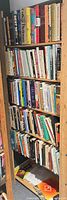 Full view of tall wooden bookshelf filled with books