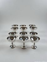 Twelve silver-plated coupes arranged in rows