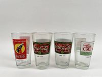 Four clear tumblers with Coca-Cola 1886-1919 graphics and logos