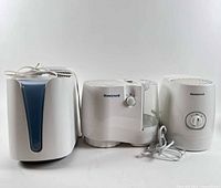 Front view of three Honeywell humidifiers showing different designs and attached power cords