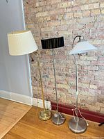 All three floor lamps standing side by side showing overall design, finishes and shades