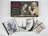 Group shot showing board game box, book, pamphlets, booklet, photo print