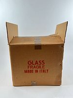 Closed cardboard box marked GLASS FRAGILE MADE IN ITALY