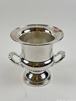 Front view of silver plated champagne chiller showing flared rim, twin handles, pedestal