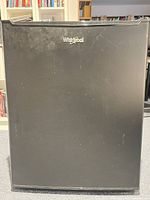 Front view of black Whirlpool compact fridge with logo visible