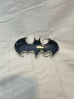 Front view showing black enamel Batman logo with silver-tone border