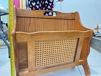 Front view showing cane panel, oak frame, carry handle