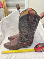 Side view of both boots with tape measure showing length ~12.5 in