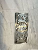Front view showing embossed $100 bill design