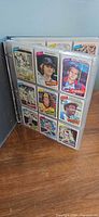 Binder open showing nine-card plastic page with 1980 Topps player fronts