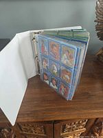 Open white binder showing pages of blue-border 1991 Donruss cards