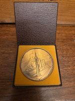 Medallion seated in open presentation case, showing scale and storage condition