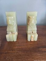 Front view of both onyx bookends showing carved figures and color