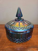 Covered candy dish showing iridescent blue carnival glass with lid in place
