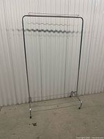 Full view of chrome rolling garment rack front