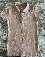 Front view of Aerion light brown polo riding shirt showing collar, placket and embroidered logo