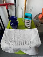 Group shot including blue vase, clear vase, cheese grater, grey pillow cover
