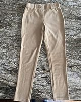 Full view of beige girls pants laid flat