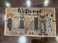 Full view of rectangular coir door mat showing text and animal silhouettes