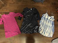 Three dresses laid out showing styles and colors