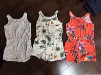Front view of three rompers laid flat