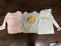 Front view of all three shirts laid flat