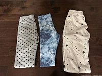 Three folded pairs of pants laid out showing patterns