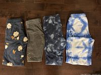 Four folded pairs of pants showing patterns and colors