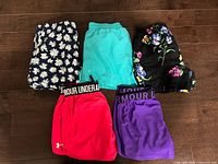 Five pairs of shorts laid flat showing fronts and colors