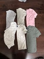 Six tops laid flat showing colours and styles