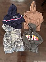 Four hoodies laid out showing colours and graphics
