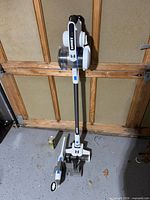 Full view of Hart cordless stick vacuum on stand with attachment