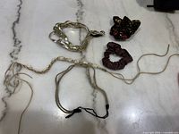 Braided headbands, scrunchies, floral hair clip on marble surface