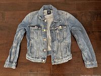 Front view of blue denim jacket laid flat showing overall style and condition