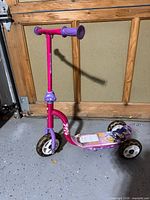Full view of the pink and purple Disney Princess three-wheel scooter