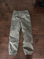 Full view of grey kids snow pants laid flat