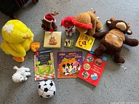 Overview of all plush toys, figurine and books arranged on floor