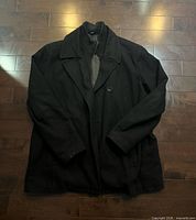 Front view of black coat showing lapel, inner collar and front button