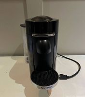Front view of Nespresso machine showing spout, drip tray and overall condition