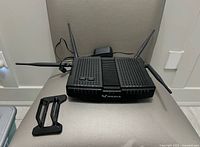 Modem router with antennas, power adapter and stand bracket on chair