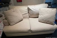 front view of white/cream loveseat with two seat and two back cushions