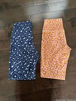 Both pairs of leggings side by side on floor showing patterns and cut