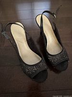 Top view of pair of black slingback heels on floor