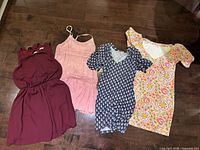 Overview of four women’s dresses laid flat