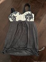 Front view of grey Lululemon top showing floral bust panel and drawstring hem